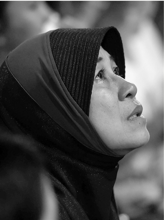 左图:在泰国首都曼谷的诗丽叻医院外,一名妇女眼含泪光